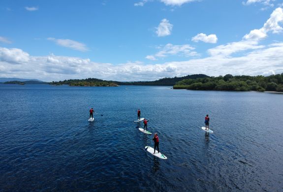 group of people paddle boarding on a lake