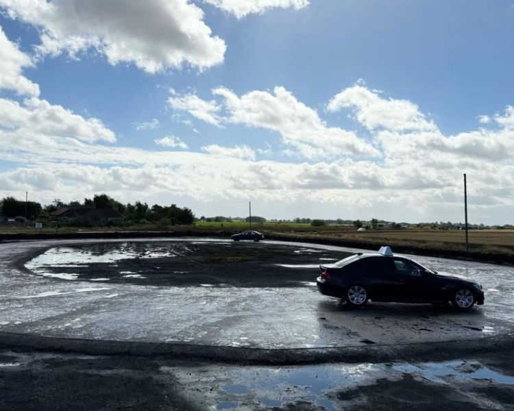 a car on a skid pan being driven on a skid pan driving experience
