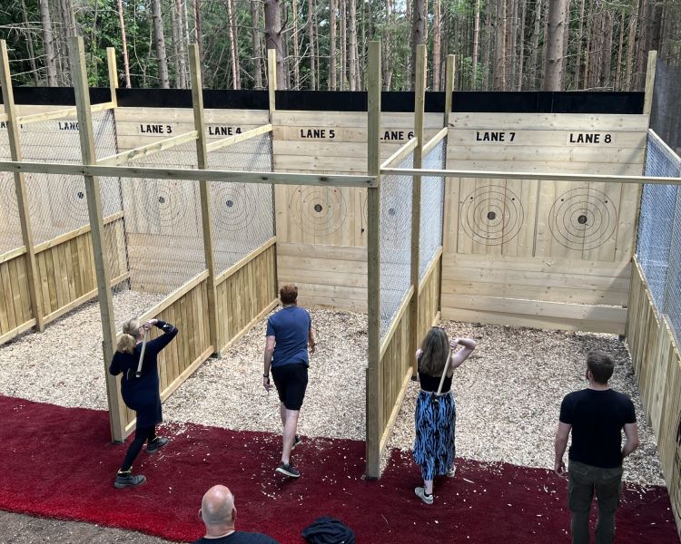 view of people throwing axes in separate wooden booths on an axe throwing experience in tunbridge wells in kent