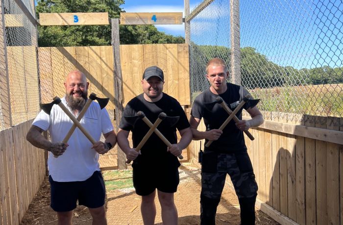 three men posing for photo holding axes on an axe throwing experience in tunbridge wells in kent