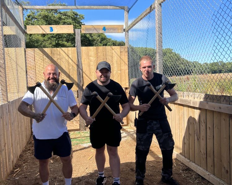 three men posing for photo holding axes on an axe throwing experience in tunbridge wells in kent