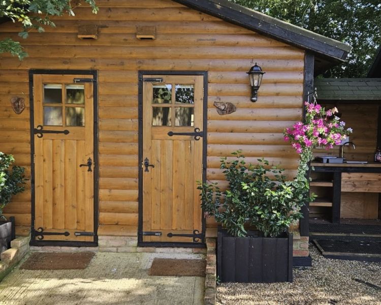 the wooden cabins with private bathrooms used for glamping experience in cambridgeshire
