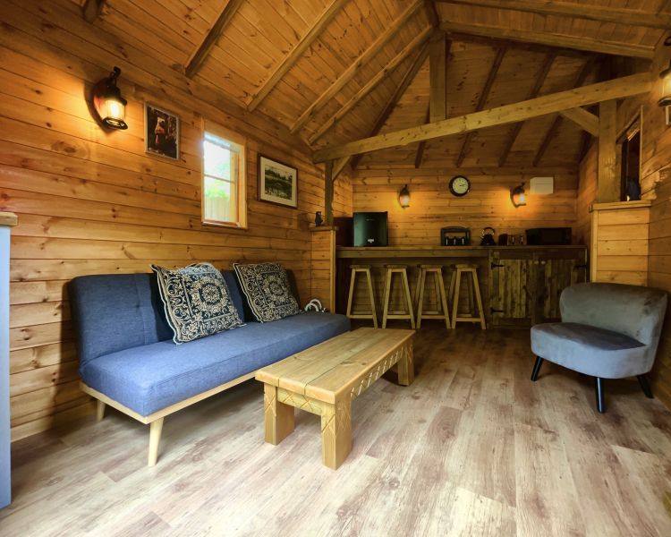 the living room and kitchenette of bears house wooden cabin used for glamping experience in cambridgeshire
