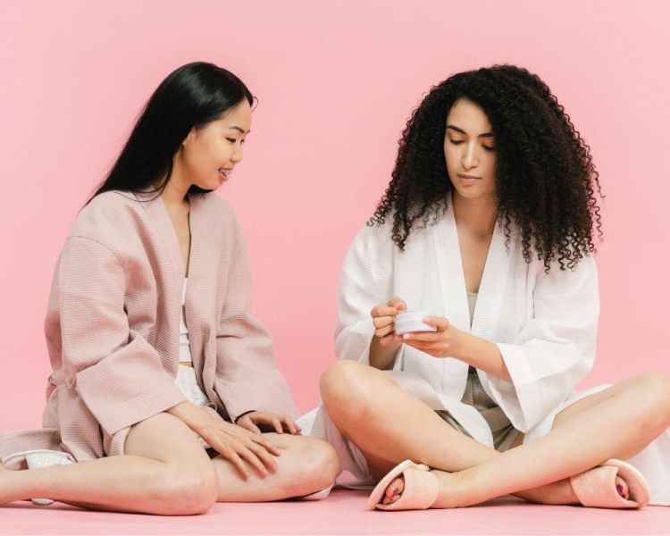 2 women in beige bathrobes chatting