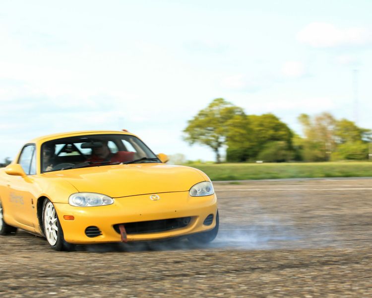 front view of a yellow sports car being driven around a race track