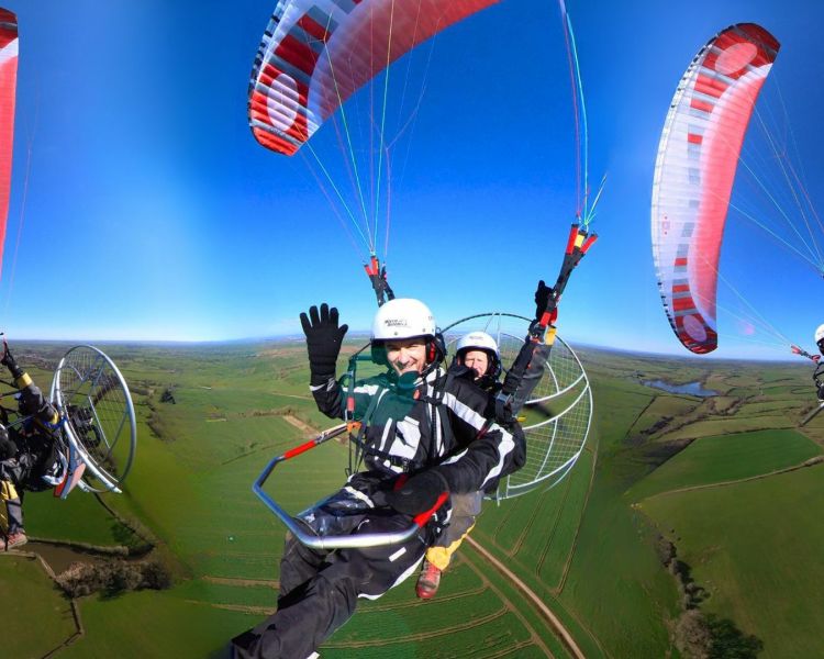 3 views of man on a tandem paramotor experience flying over green fields against a blue sky