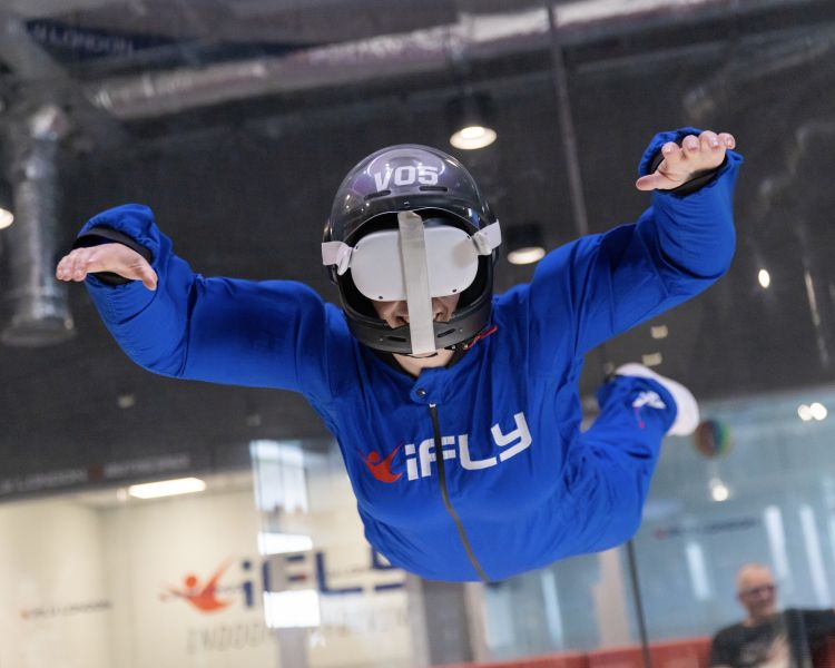 person on an indoor skydive wearing a vr headset