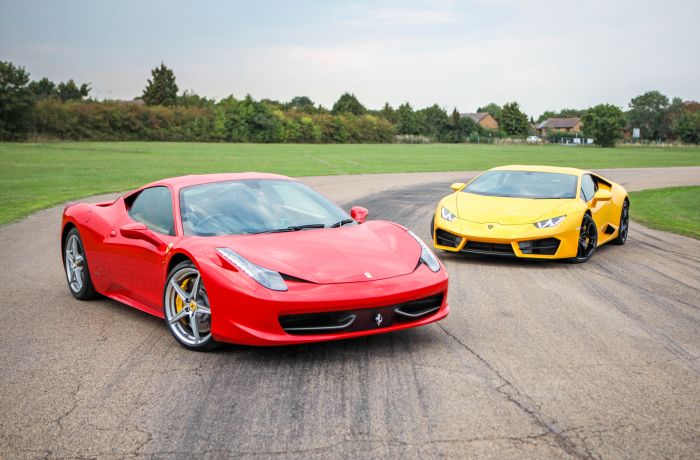a red ferrari and a yellow lamborghini on a race track for a driving experience day