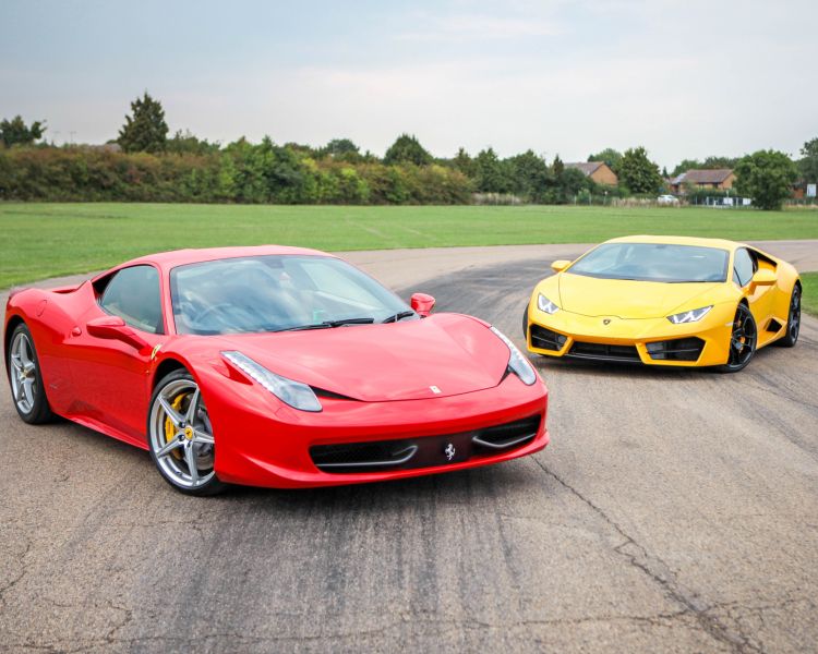 a red ferrari and a yellow lamborghini on a race track for a driving experience day