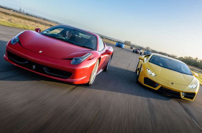 a red ferrari and a yellow lamborghini on a race track for a driving experience day