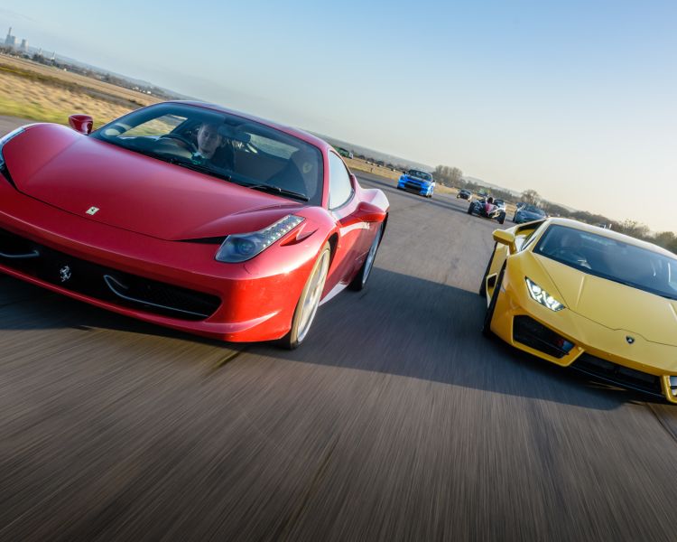 a red ferrari and a yellow lamborghini on a race track for a driving experience day