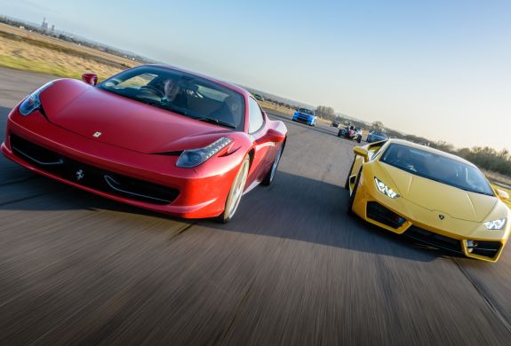 a red ferrari and a yellow lamborghini on a race track for a driving experience day