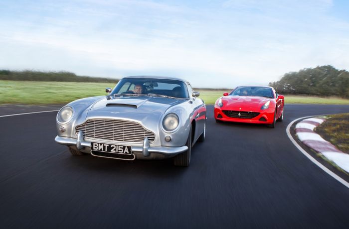 a red supercar and a silver classic car on a race track for a supercar vs classic car driving experience