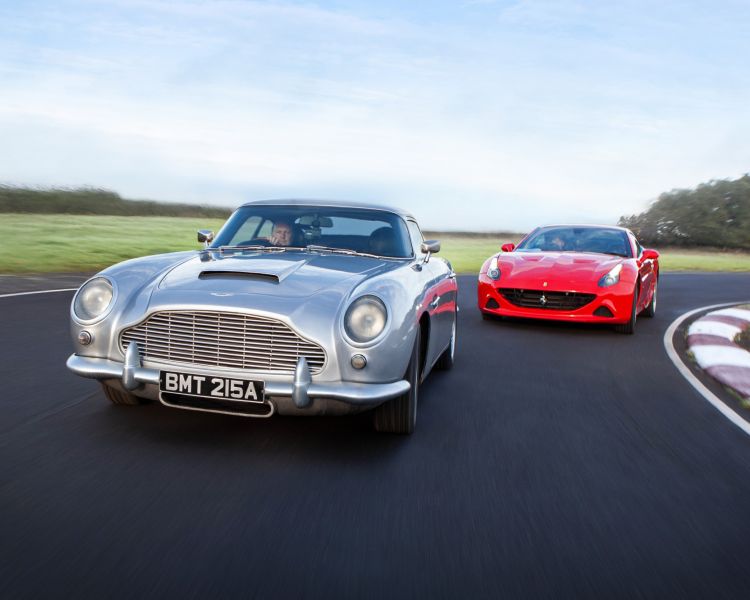 a red supercar and a silver classic car on a race track for a supercar vs classic car driving experience