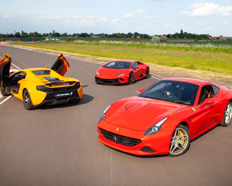 a yellow lamborghini and two red ferraris on a race track for a driving experience