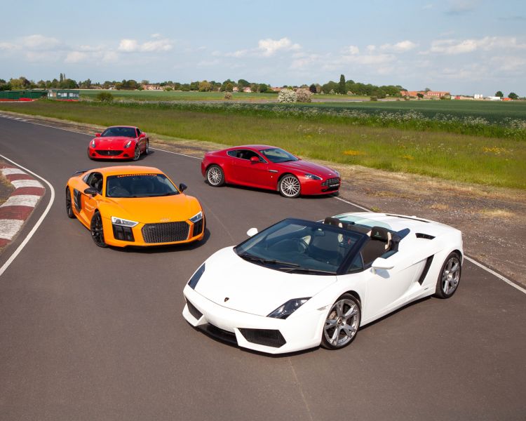 four supercars on a race track for a supercar vs classic car driving experience