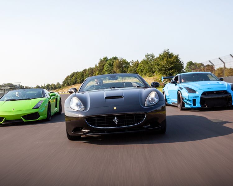 three supercars on a race track for a supercar vs classic car driving experience