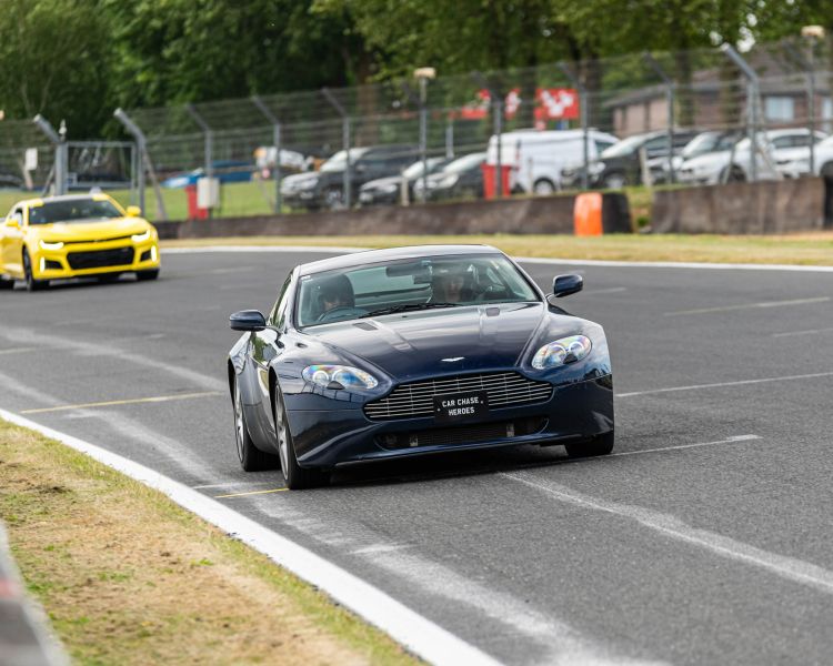 a black supercar followed by other supercars on a race track for a premium car driving experience