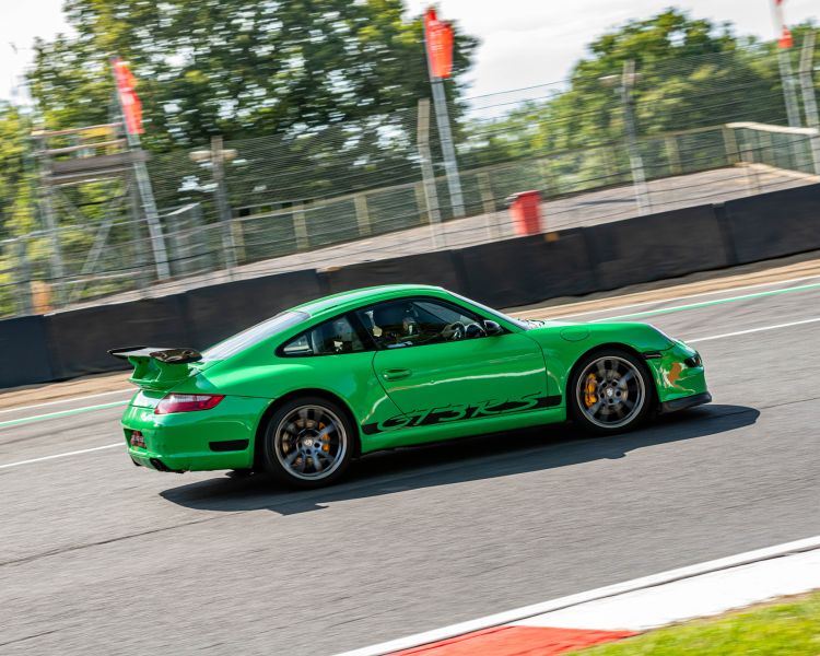 a green supercar on a race track for a premium car driving experience