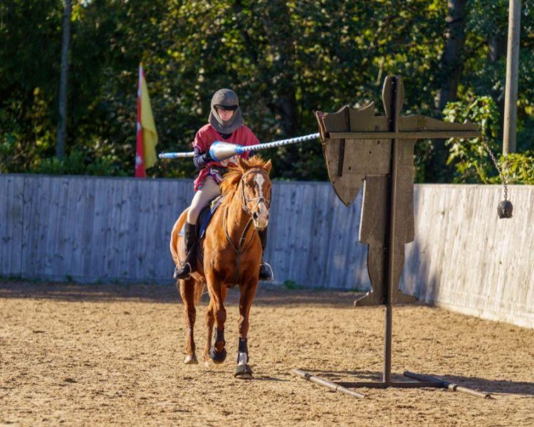 person on horseback dressed as a medieval knight on a jousting experience