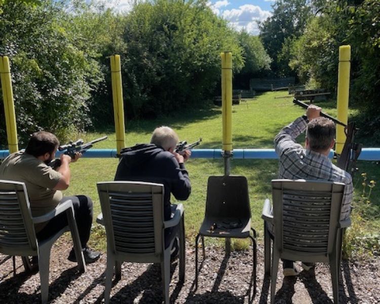 People sitting in a row on a rifle shooting experience
