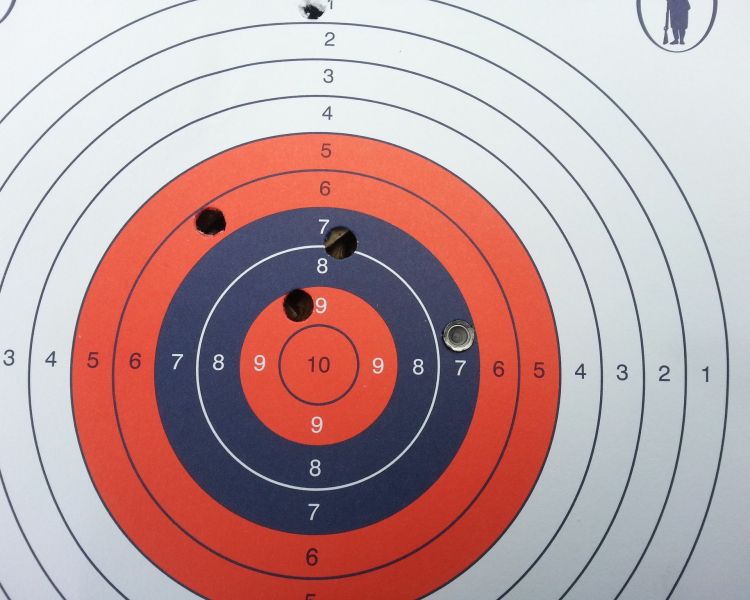 a close up of a shooting target showing three bullet holes as part of an air rifle shooting experience