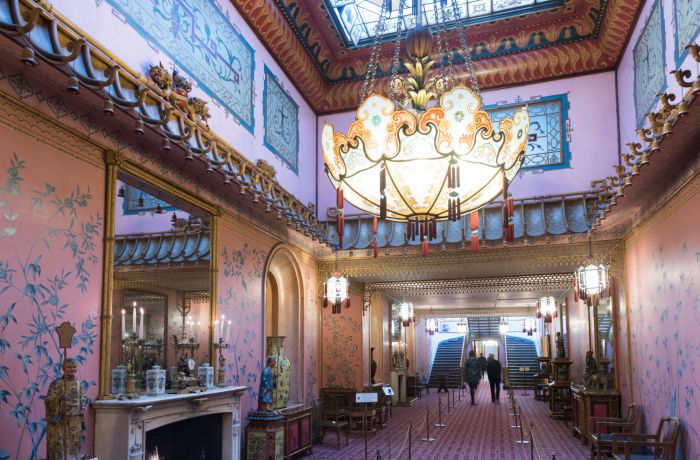 the inside of the long gallery in the royal pavilion brighton, a very grand room with ornate furniture and chandelier