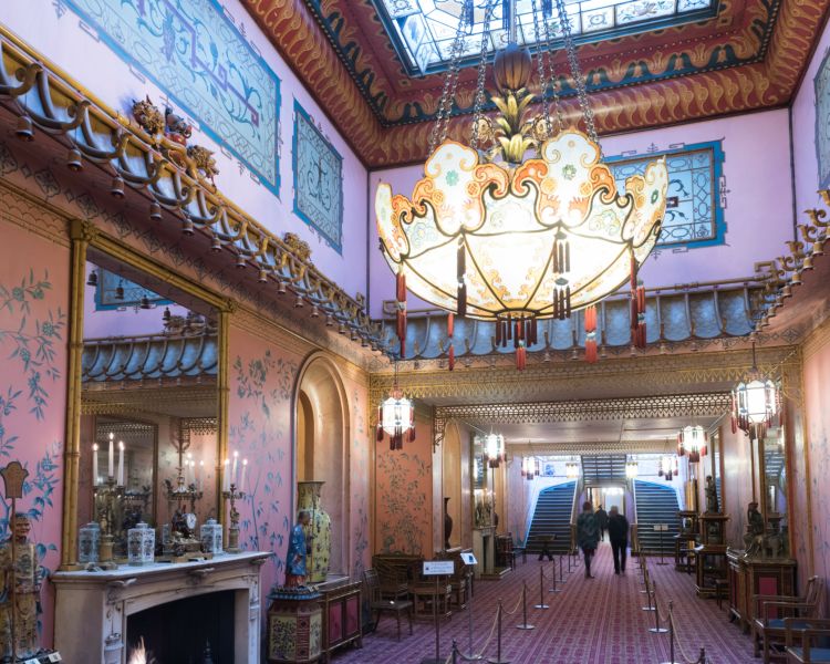 the inside of the long gallery in the royal pavilion brighton, a very grand room with ornate furniture and chandelier