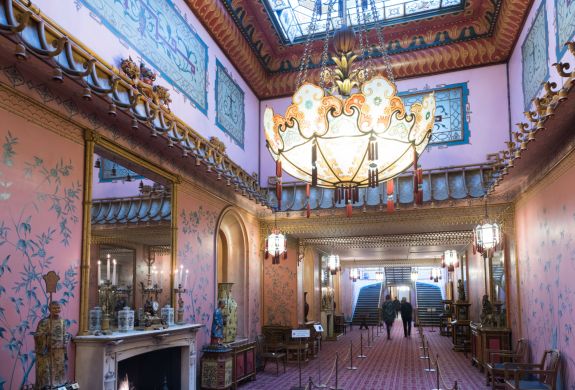 the inside of the long gallery in the royal pavilion brighton, a very grand room with ornate furniture and chandelier