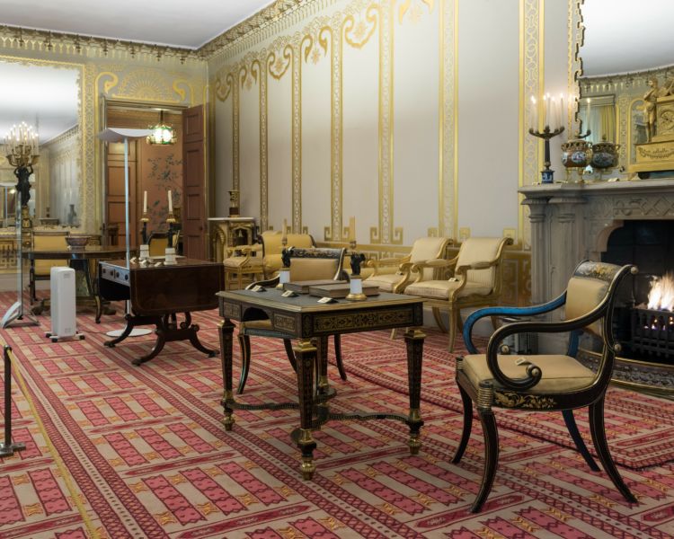 the music room in the royal pavilion brighton, with grey and gold walls, a red patterned carpet and antique furniture