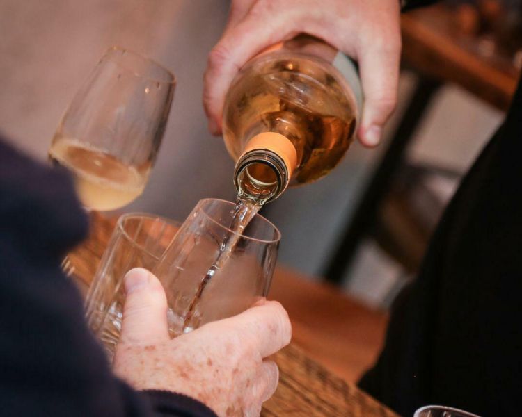 white wine being poured into a wine glass at the wine cellar in brighton