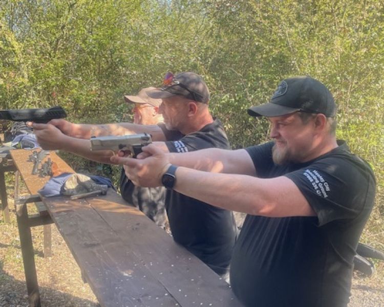 two men holding pistols on a shooting experience