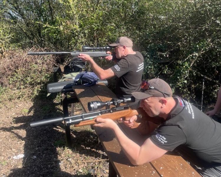 row of men shooting rifles on a shooting experience