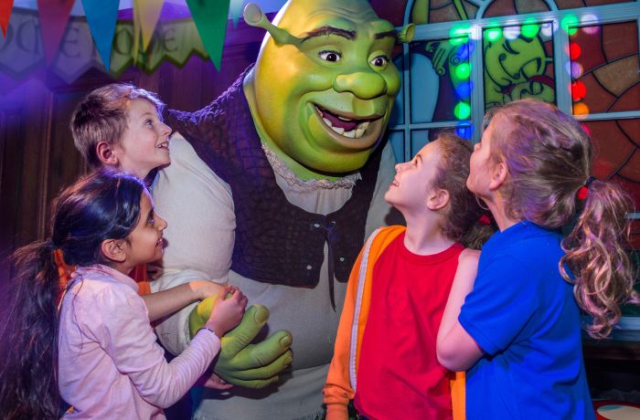 group of children meeting shrek as part of the shrek adventure experience in london