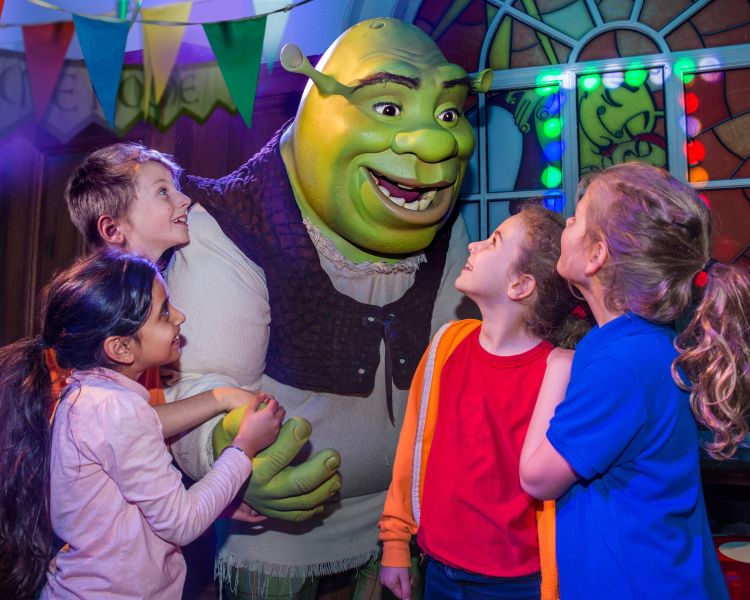 group of children meeting shrek as part of the shrek adventure experience in london