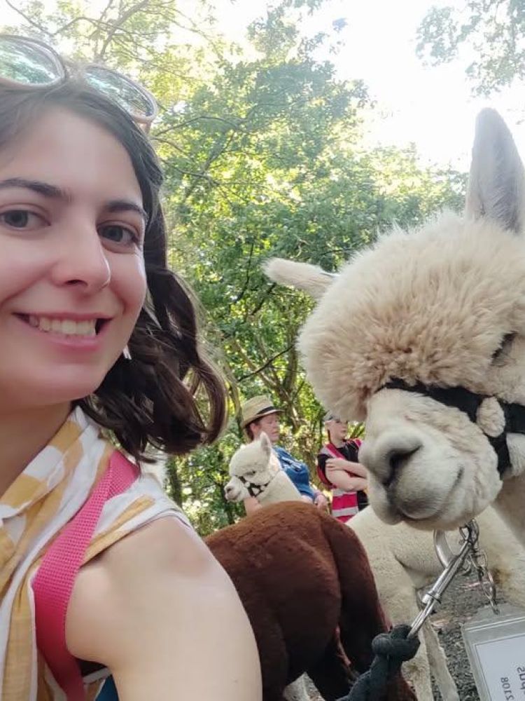young woman taking a selfie with an alpaca on an alpaca walk experience