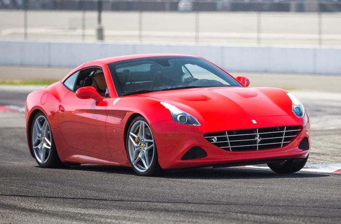 a red ferrari california driving around a race track as part of a ferrari driving experience day