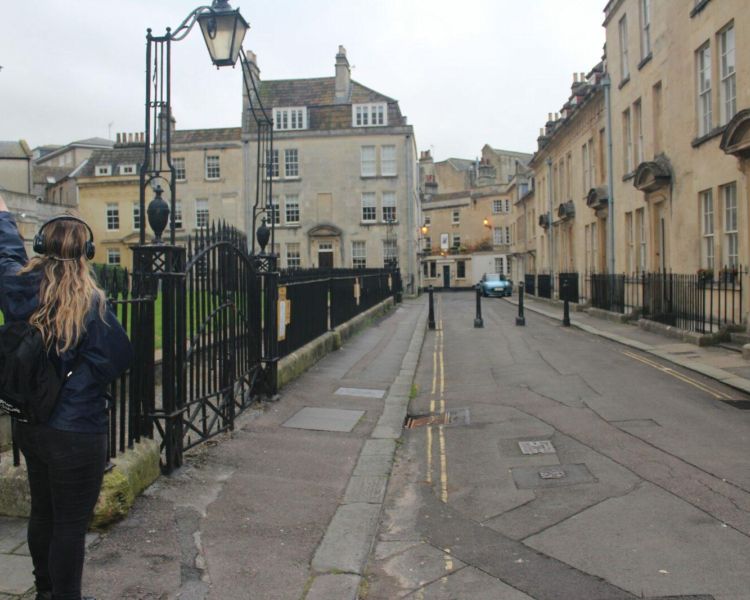 Girl walking through the streets of bath on a bridgerton walking tour