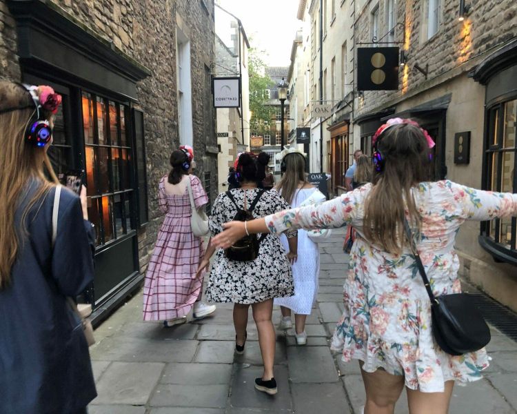Girls walking through cobbled streets in bath on a bridgerton walking tour