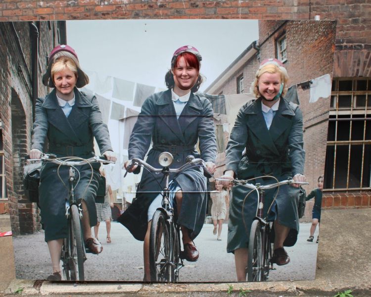 Women posing behind a call the midwife picture on a call the midwife locations tour