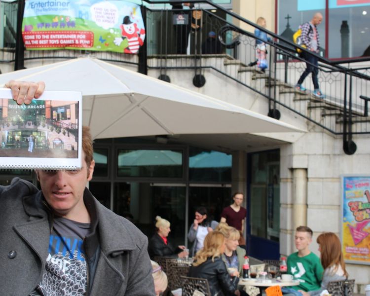 Man holding photo from doctor who series in front of a location seen on a doctor who locations walking tour in cardiff