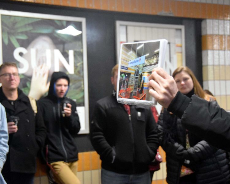 Group looking photo held by guide seen on a spy movie film locations walking tour in london