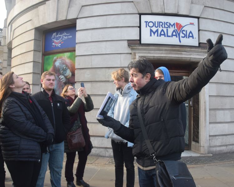 Guide talking to group on a london street seen on a spy movie film locations walking tour in london