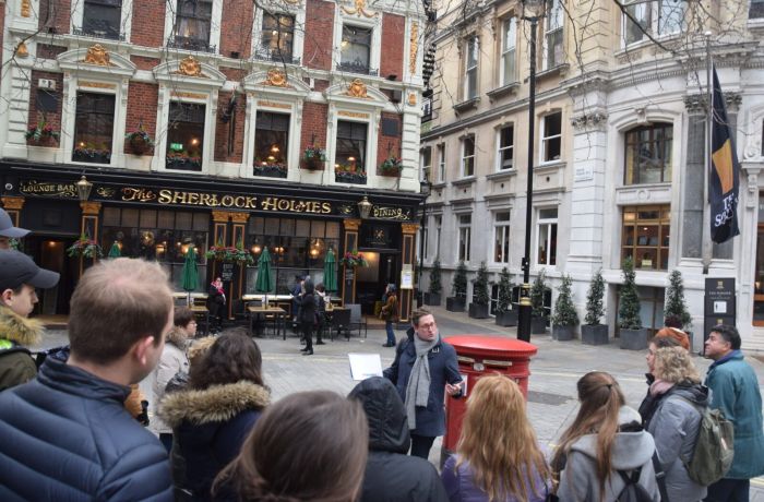 Guide talking to group outside the sherlock holmes pub seen on a sherlock holmes walking tour in london