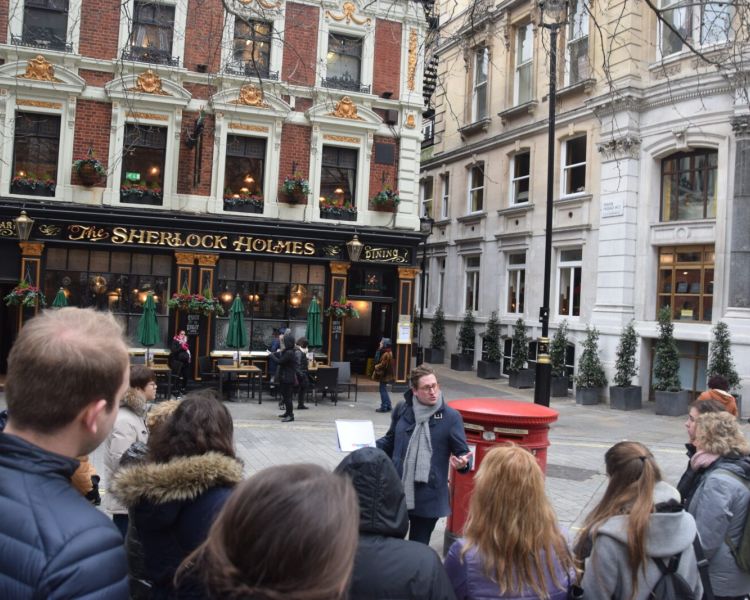 Guide talking to group outside the sherlock holmes pub seen on a sherlock holmes walking tour in london