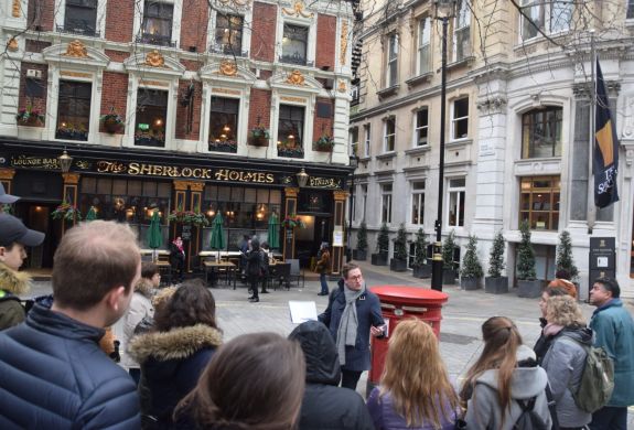 Guide talking to group outside the sherlock holmes pub seen on a sherlock holmes walking tour in london
