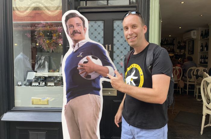Man posing with cardboard cutout of ted lasso seen on a ted lasso walking tour in london