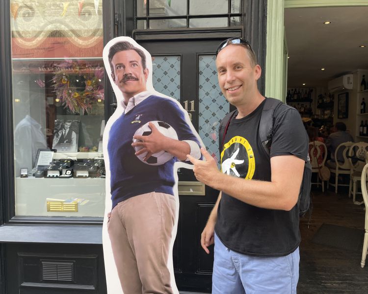 Man posing with cardboard cutout of ted lasso seen on a ted lasso walking tour in london