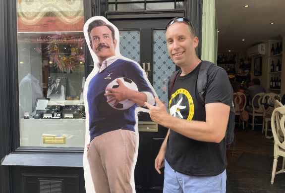 Man posing with cardboard cutout of ted lasso seen on a ted lasso walking tour in london