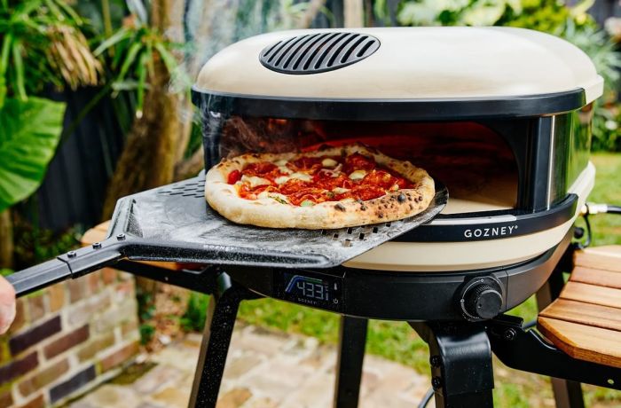 pizza making in an outdoor pizza oven at cookery class